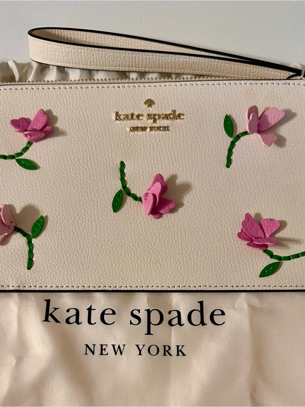 Kate Spade white wristlet with lilac floral appliqués and green leaves